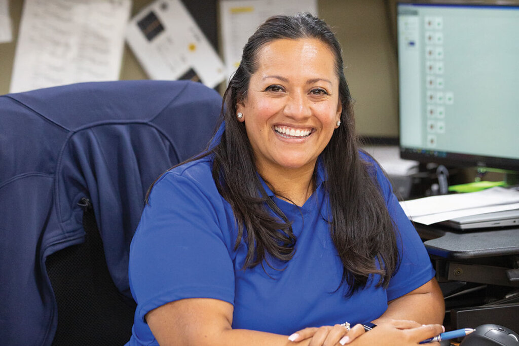 Female employee in blue shirt sitting at office desk