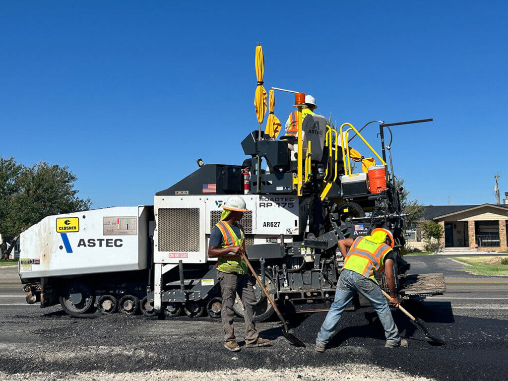 Employees laying asphalt