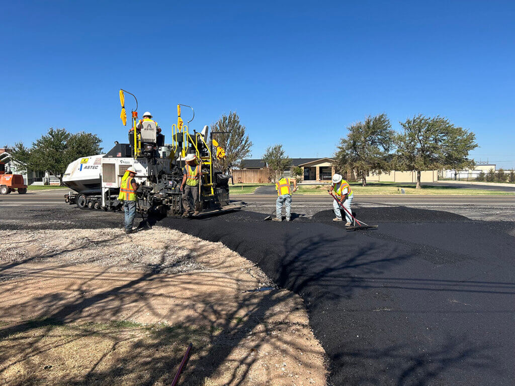 Employees laying asphalt