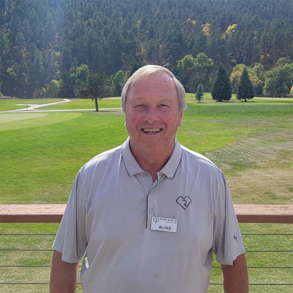 Man in gray Hart Ranch polo in front of Hart Ranch Golf course