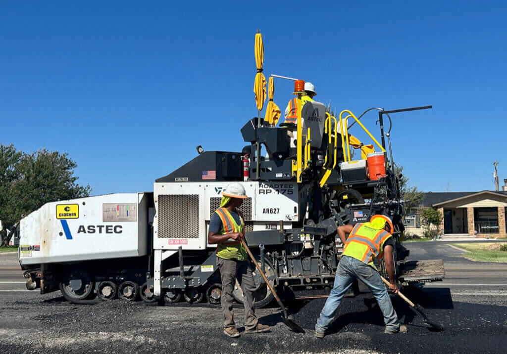 Employees laying asphalt